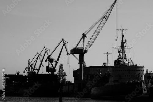 unloading a ship in port, ships standing near the shore, black and white photography