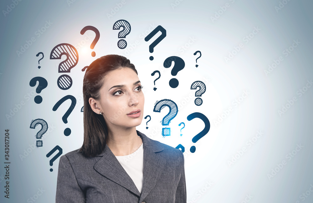 Thoughtful businesswoman and question marks Thoughtful businesswoman and question marks