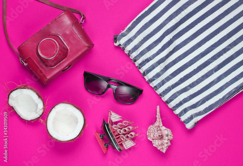 Summer creative background. Beach striped bag, accessories on pink background. Top view. Flat lay