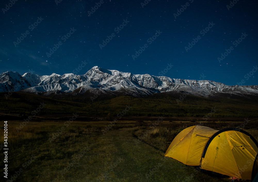 yellow tent at night on the background of a mountain range, stars, dark, Altai