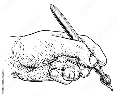 A hand holding an artists paintbrush or paint brush in a vintage engraved or etched woodcut print style