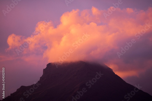 Coloured purple violet sunset at the muntain with white clouds above - beautiful mounts landscape with amazing colors - concept of nature and outdoors