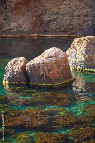 Stones at sea and plants in turquoise water. Beautiful panoramic views of the sea, landscape, coastal travel and nature