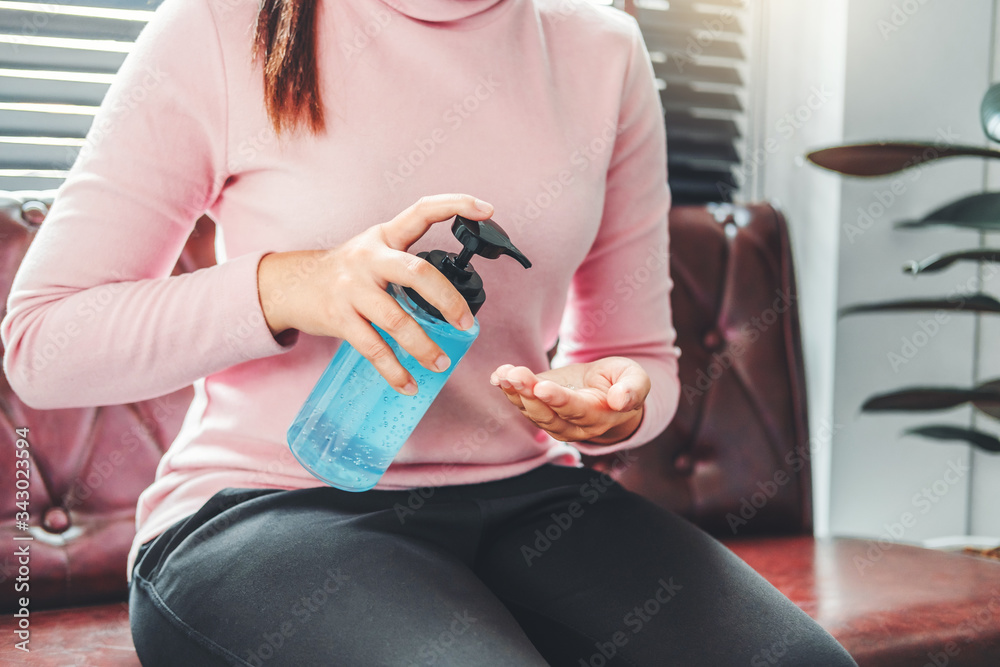 Woman using a hand sanitizer alcohol gel to wash hands to prevent viruses and diseases at home Woman using a hand sanitizer alcohol gel to wash hands to prevent viruses and diseases at home