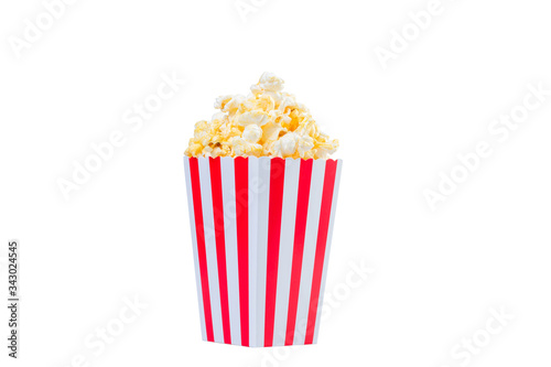 Popcorn in red and white striped cardboard bucket isolated on white background. Movie Popcorn isolated on white with clipping path. Tasty salted popcorn in striped paper cup .
