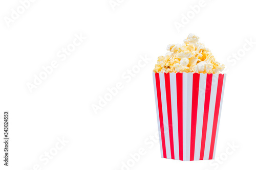 Popcorn in red and white striped cardboard bucket isolated on white background. Movie Popcorn isolated on white with clipping path. Tasty salted popcorn in striped paper cup .