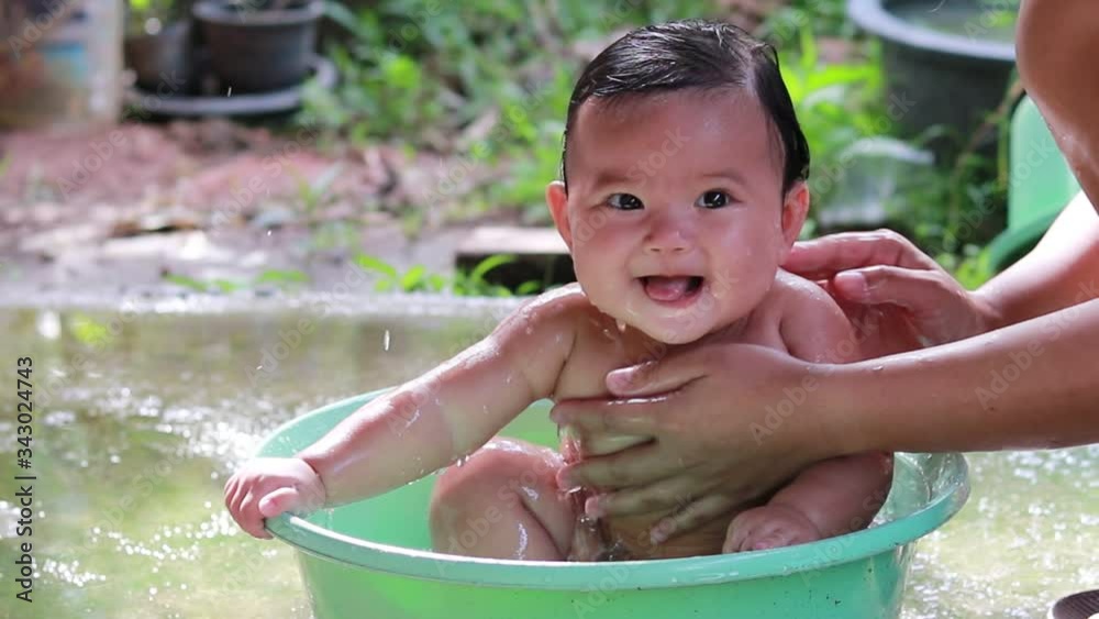 Stockvideo Close up of Cute little girl bathing in a tub With her mother | Adobe Stock