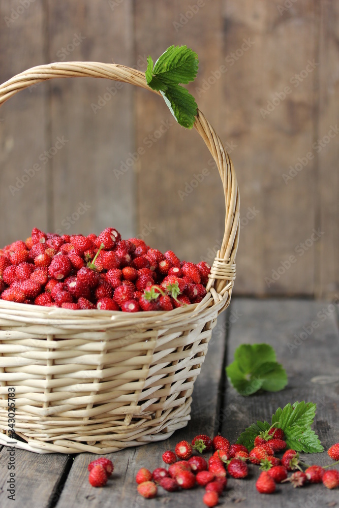 Gardening and agriculture. Strawberry harvest in a basket with green leaves on an old wooden background. Rustic. Background image, copy space Gardening and agriculture. Strawberry harvest in a basket with green leaves on an old wooden background. Rustic. Background image, copy space