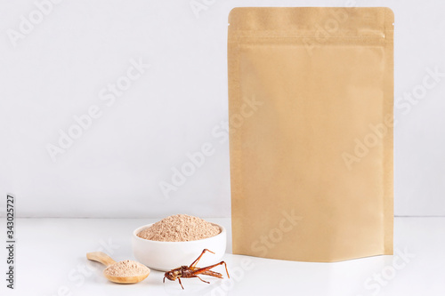 Grasshopper insect powder. Orthoptera flour processed from Insects baked food is eating edible in bowl and spoon with packaging bag, it is good source of protein. Entomophagy and future food concept. photo