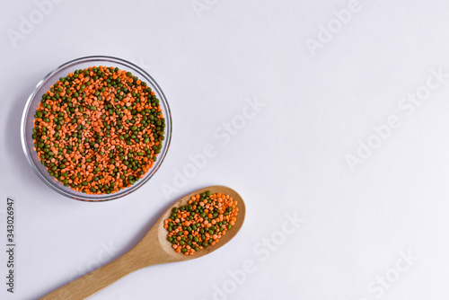 Top view of red lentils and green mung bean in a bowl on a white background. Vegan. Copy space. 