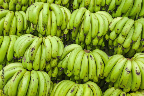 Bunches of green bananas on indian market stall