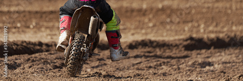 Obraz na plátně Racer child on motorcycle participates in motocross race, active extreme sport