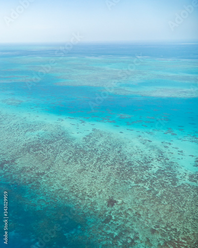 Great Barrier Reef Blue Ocean Sea view. Beautiful aqua   turquoise waters  with coral reef patterns in the ocean. View from helicopter  on vacation. Marine life  global warming  protection  island