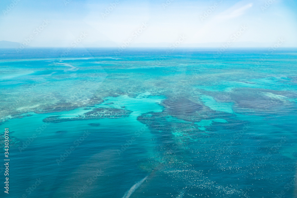 Great Barrier Reef Blue Ocean Sea view. Beautiful aqua & turquoise waters, with coral reef patterns in the ocean. View from helicopter, on vacation. Marine life, global warming, protection, island Great Barrier Reef Blue Ocean Sea view. Beautiful aqua & turquoise waters, with coral reef patterns in the ocean. View from helicopter, on vacation. Marine life, global warming, protection, island
