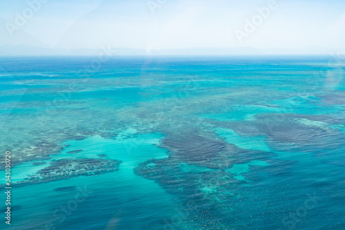 Great Barrier Reef Blue Ocean Sea view. Beautiful aqua & turquoise waters, with coral reef patterns in the ocean. View from helicopter, on vacation. Marine life, global warming, protection, island © Jam Travels