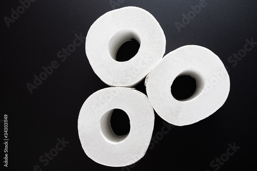 Hygiene and cleanliness. Rolls of white toilet paper on a black background