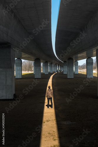 Man standing under bridge in a light trail. 