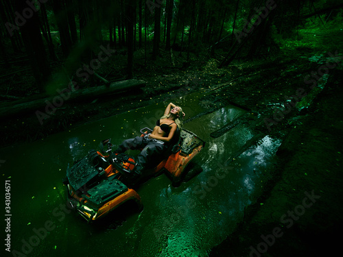 Beautiful girl on a ATV in a green swamp in the forest