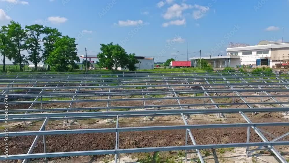 Building of innovative solar power station in nature. Metal basis for future solar panels on the field. Motion camera back. Building of innovative solar power station in nature. Metal basis for future solar panels on the field. Motion camera back.