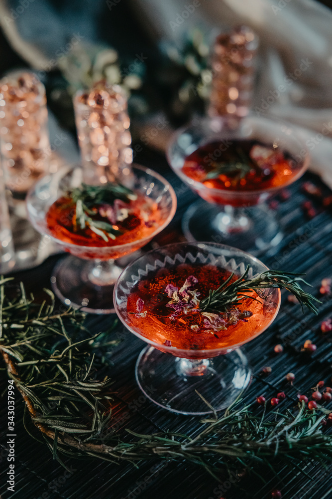 three glasses of red cocktails. Glasses of delicious strawberry daiquiri with rosemary three glasses of red cocktails. Glasses of delicious strawberry daiquiri with rosemary