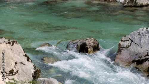 Soca river in Slovenia splashing over rocks, slow motion right pan photo