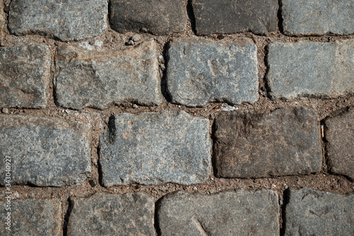 The granite block pavement of the old street is photographed close-up.