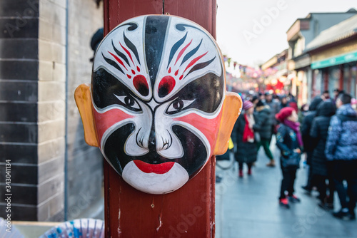 Traditional Beijing Opera Mask in front of a gift shop in Liulichang hutong, famous shopping area near Qianmen Street in Beijing city, China