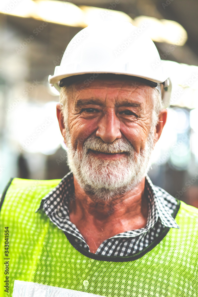 Portrait of senior engineering architect builder wearing protective hardhat working at Metal lathe industrial manufacturing factory. Engineer Operating lathe Machinery. Elderly people Portrait of senior engineering architect builder wearing protective hardhat working at Metal lathe industrial manufacturing factory. Engineer Operating lathe Machinery. Elderly people