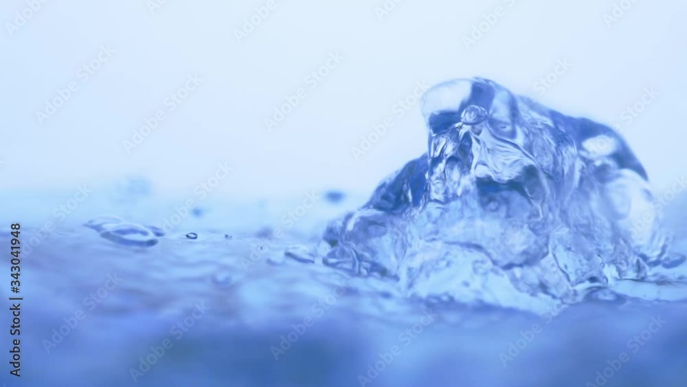 Water splash surface filling the frame with slow motion the water drop and waving liquid with an air bubble on a white background. 1080p 23.98fps
