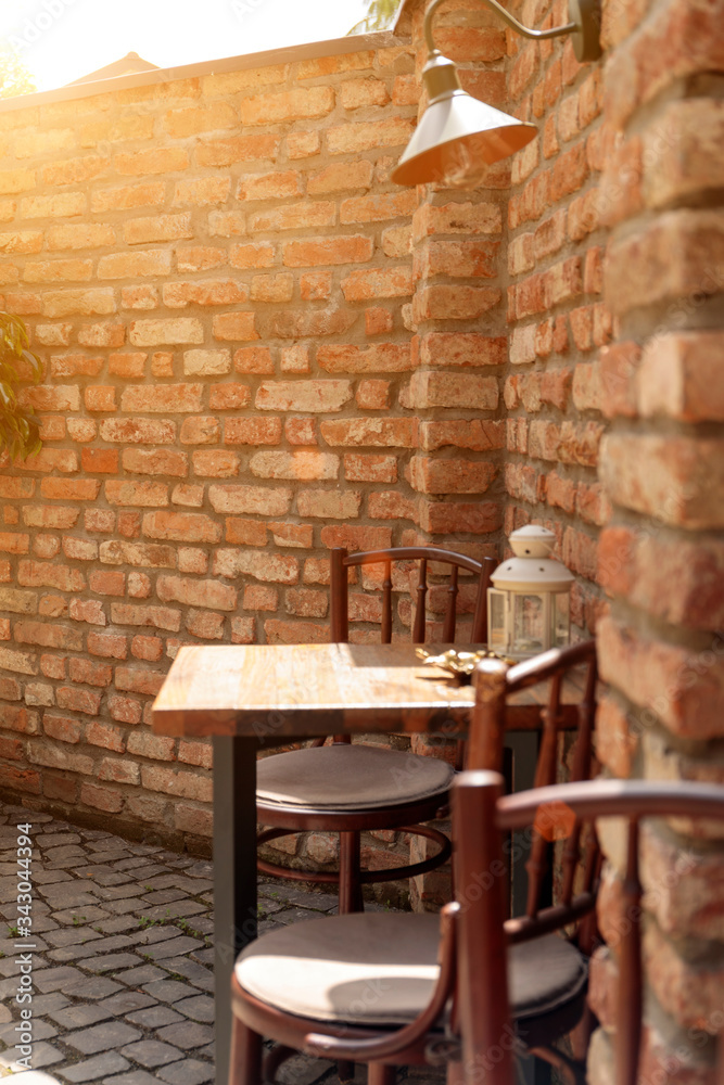 Street view of a empty coffee terrace with tables and chairs in old town. Small depth of field. Street view of a empty coffee terrace with tables and chairs in old town. Small depth of field.