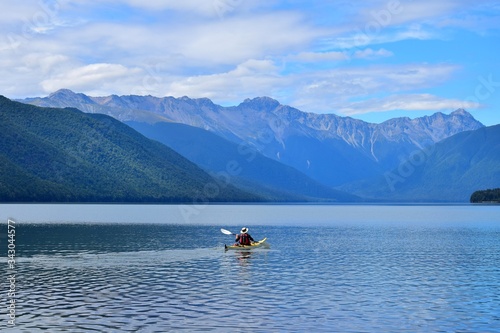 A man paddling across Lake Rotoroa in the Nelson Lakes National Park, New Zealand, South Island.
