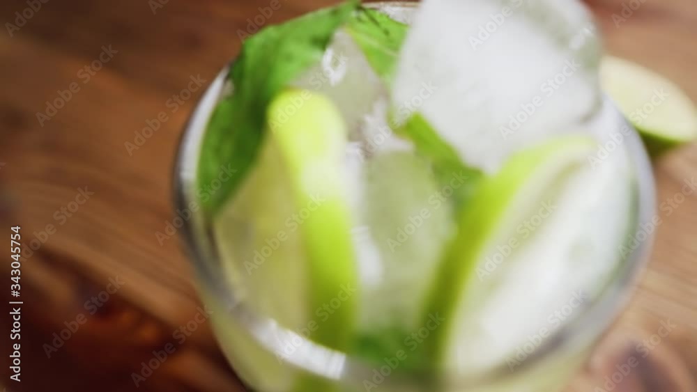 Fresh cocktail with ice, lime and mint, close-up, dolly shot. Fresh cocktail with ice, lime and mint, close-up, dolly shot.