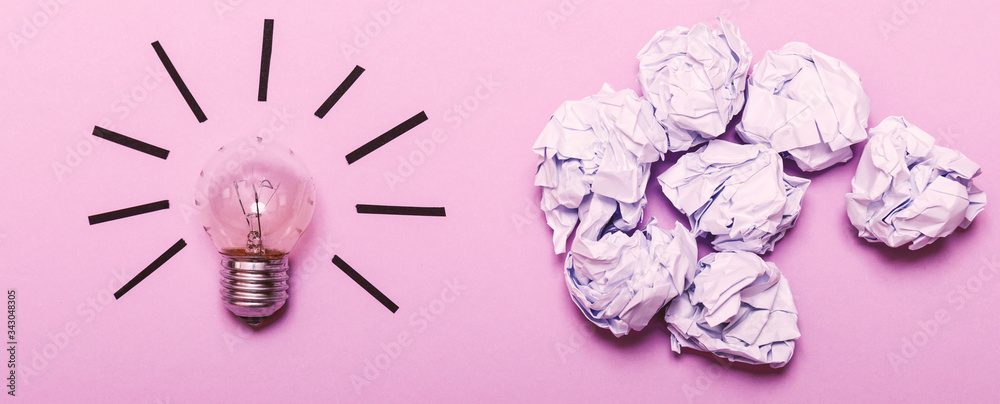 Inspiration concept crumpled paper and light bulb metaphor for good idea. White crumpled paper and light bulb on purple background, flat lay. Inspiration concept crumpled paper and light bulb metaphor for good idea. White crumpled paper and light bulb on purple background, flat lay.