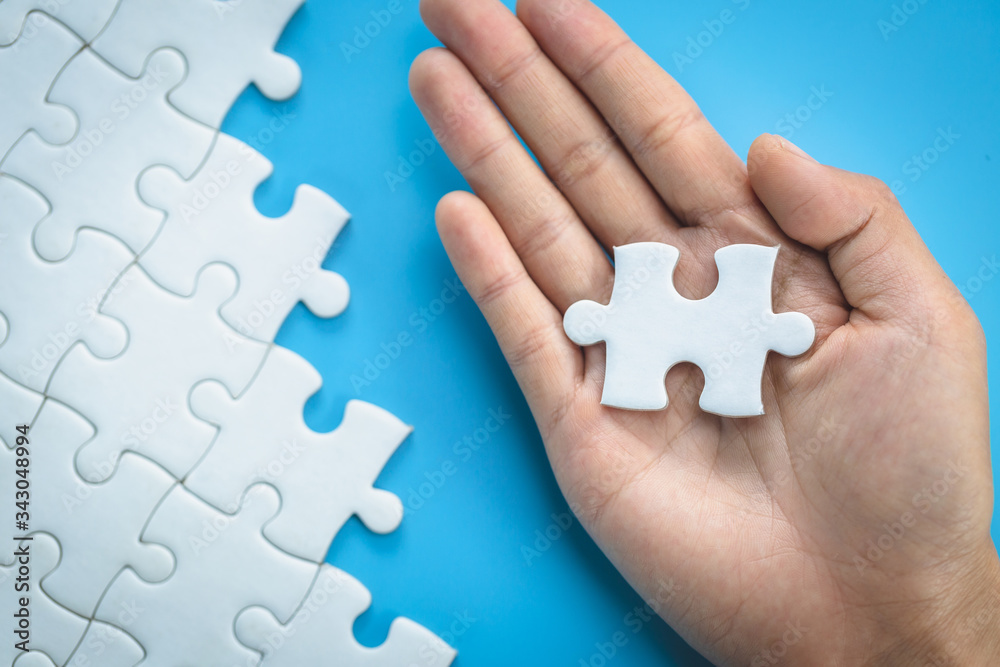 White jigsaw in the hands of humans, The correct solution. Teamwork, Solving and completing the task. Last piece of jigsaw puzzle. Assembling jigsaw puzzle pieces. White jigsaw in the hands of humans, The correct solution. Teamwork, Solving and completing the task. Last piece of jigsaw puzzle. Assembling jigsaw puzzle pieces.