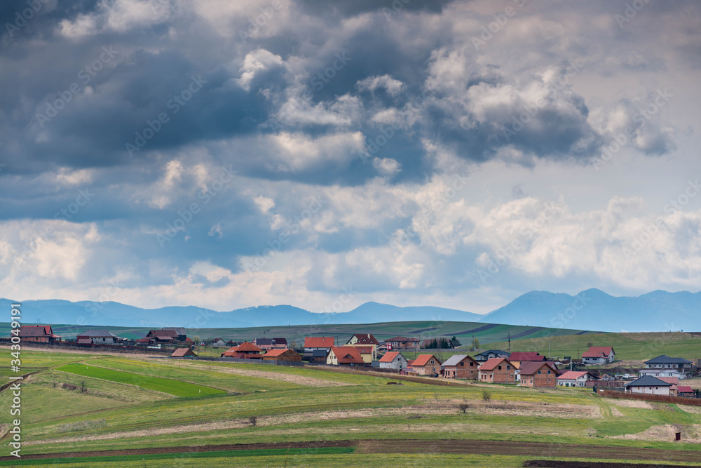  New residential area near a small town, colorful meadow with stormclouds.