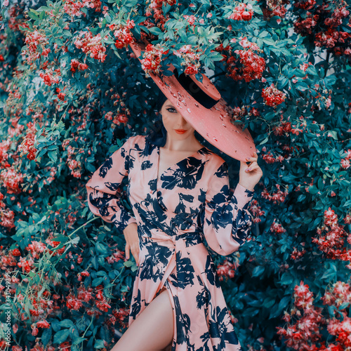 Obraz na płótnie Art fantasy Sexy luxury woman stands near flowering bush red rose