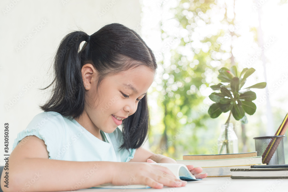 pretty stylish schoolgirl studying homework during online lesson at home, social distance during quarantine, self-isolation, online education concept, home school. girl does homework in her copybook pretty stylish schoolgirl studying homework during online lesson at home, social distance during quarantine, self-isolation, online education concept, home school. girl does homework in her copybook