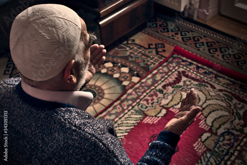 Obraz na płótnie Very old Turkish Muslim man at his 80's praying to Allah at home on his rug