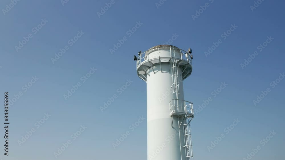 Aerial view of a chimney in an industrial plant in a blue sky Aerial view of a chimney in an industrial plant in a blue sky
