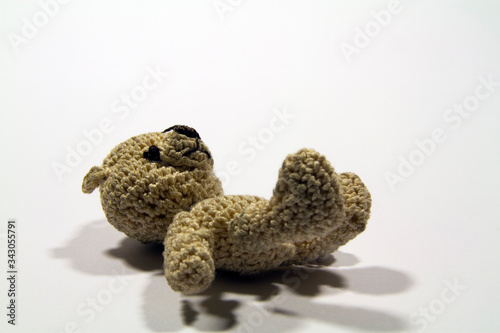 Cute brown crochet teddy bear with white background © Branislava