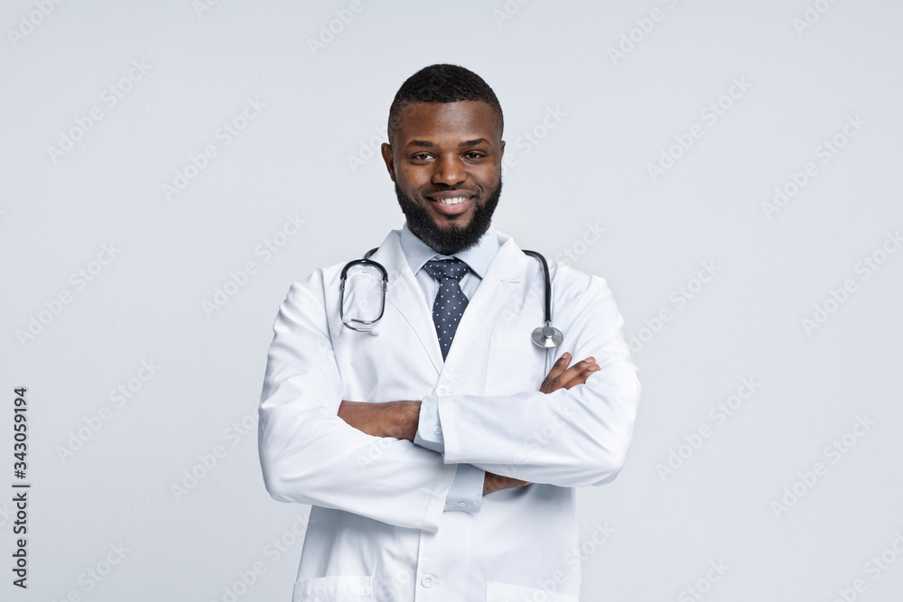Cheerful black doc posing over white studio background Cheerful black doc posing over white studio background