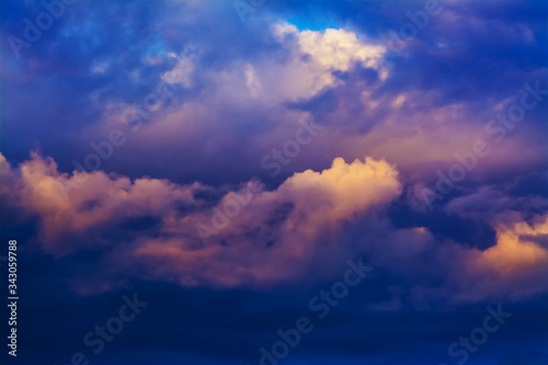 The sky is completely covered by orange-blue clouds illuminated by the sun. Sunset or dawn.