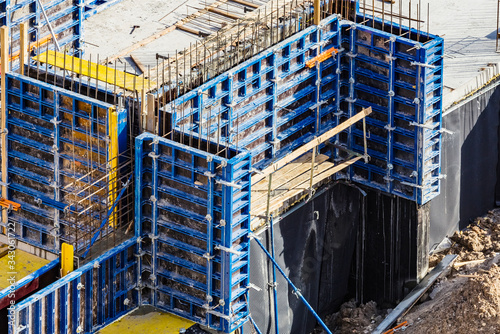Installed formworks and iron rebars or reinforcing bar for reinforced concrete partitions at the construction site of a large residential building. photo