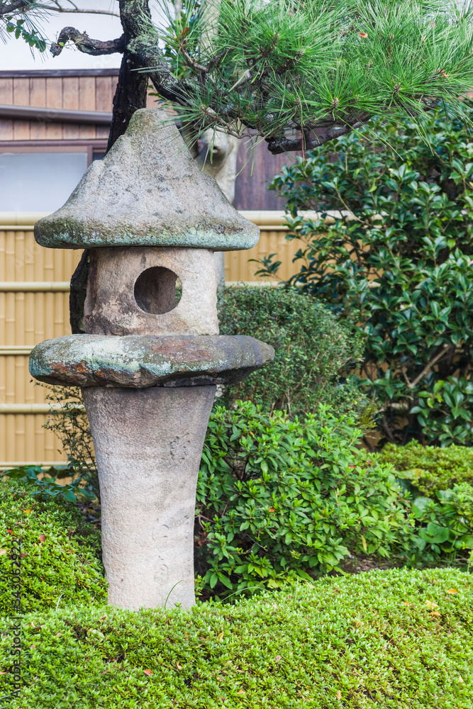A fragment of the Japanese garden. Stone lantern and bushes A fragment of the Japanese garden. Stone lantern and bushes