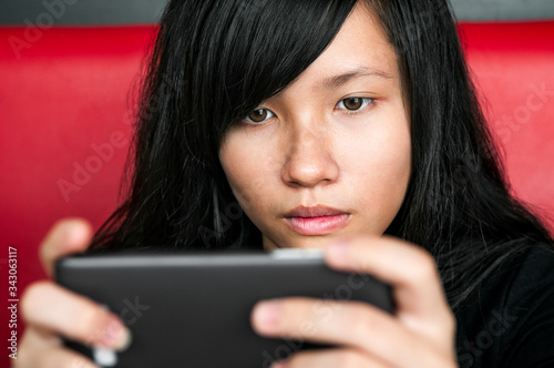 Close-up of young woman using smartphone at home. photo