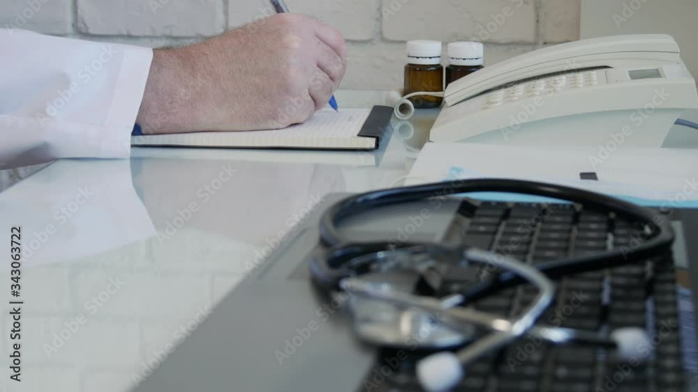 Doctor looking to some medication and prescribing a treatment, physician write a medical recipe in the hospital consultation room Doctor looking to some medication and prescribing a treatment, physician write a medical recipe in the hospital consultation room