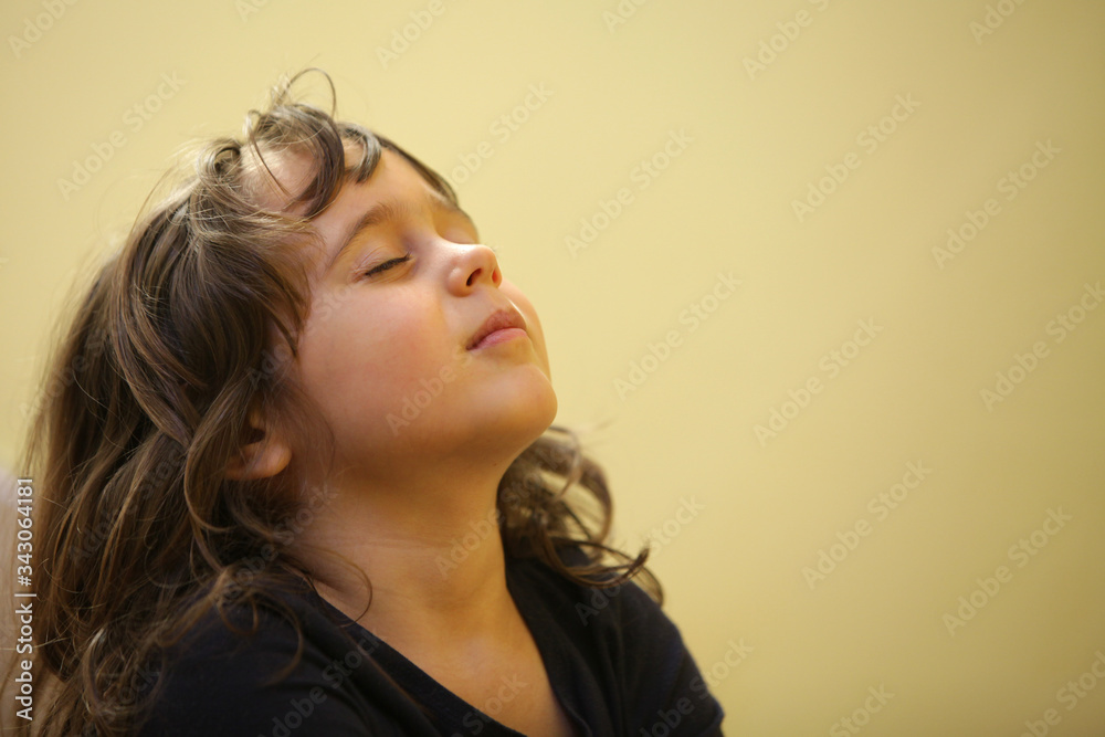 4-5 year old girl taking a deep breath on white background Stock