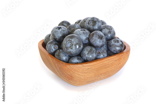 Tasty blueberries in a wooden bowl isolated on white