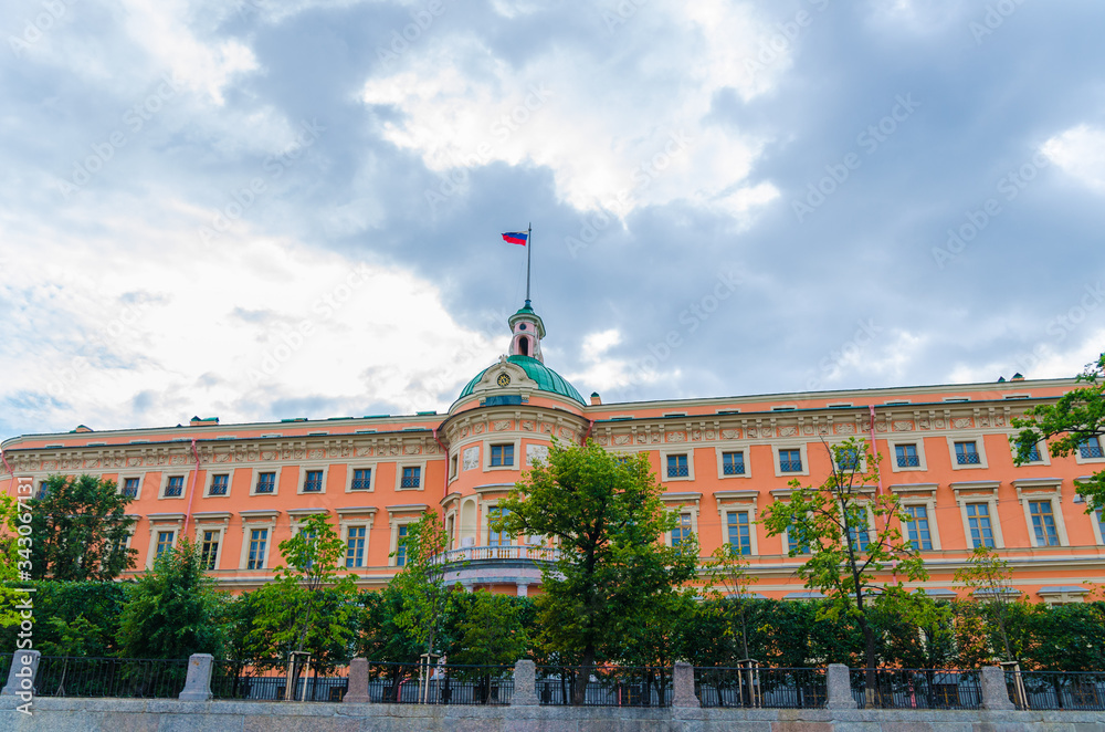 Naklejka premium St. Michael's Castle or Mikhailovsky Castle or the Engineers' Castle with russian flag on top, blue dramatic sky background, Saint Petersburg Leningrad city, Russia