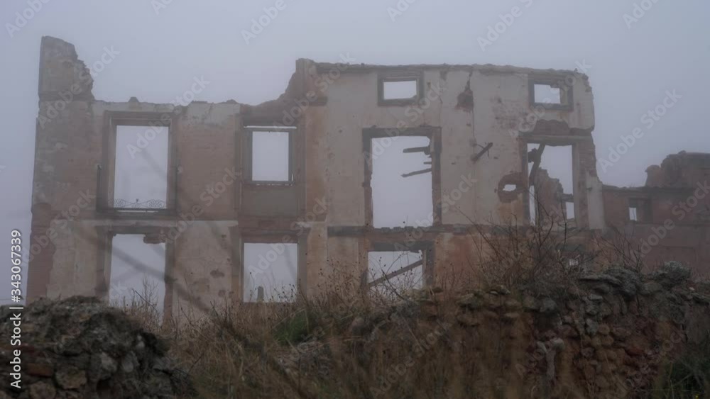 Ruins of building after bombing. War devastation in a cold misty winter Ruins of building after bombing. War devastation in a cold misty winter